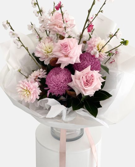 A bouquet of flowers in pinks and burgundy tones, roses, dahlias, disbud chrysanthemum and cherry blossom. LULLY & ROSE Floral Studios Designer Bouquet for same day flower delivery Gold Coast