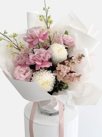 A bouquet of flowers in white and pinks, roses, stock flower, delphinium, disbud chrysanthemum. LULLY & ROSE Floral Studios Designer Bouquet for same day flower delivery Gold Coast