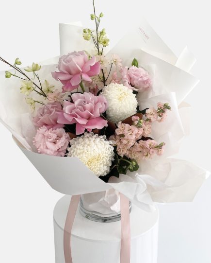 A bouquet of flowers in white and pinks, roses, stock flower, delphinium, disbud chrysanthemum. LULLY & ROSE Floral Studios Designer Bouquet for same day flower delivery Gold Coast