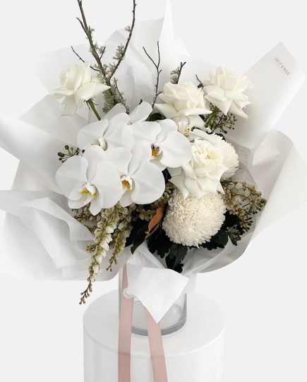 A classic style bouquet of white on white flowers, roses, phalaenopsis orchid stem, disbud chrysanthemum, andromeda, Ivy Berry and moss sticks. Designer Bouquet for same day flower delivery Gold Coast