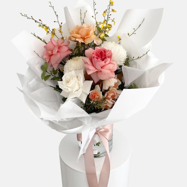 A colourful bouquet of flowers in peach, lemon tones, roses, disbud chrysanthemum, oncidium orchids and daffodils. Designer Bouquet for same day flower delivery Gold Coast
