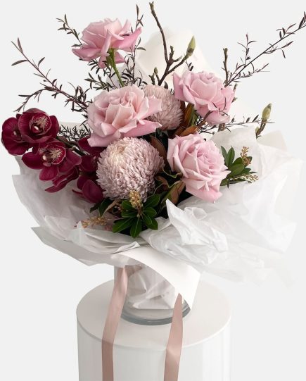 A romantic style bouquet in burgundy and vintage pink tones, roses, cymbidium orchid stem, disbud chrysanthemum, Ivy Berry and willow branches. Designer Bouquet for same day flower delivery Gold Coast