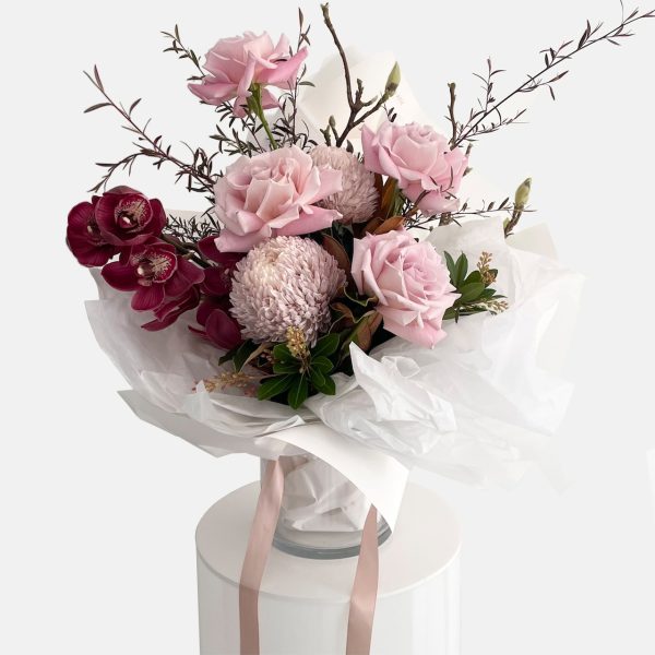 A romantic style bouquet in burgundy and vintage pink tones, roses, cymbidium orchid stem, disbud chrysanthemum, Ivy Berry and willow branches. Designer Bouquet for same day flower delivery Gold Coast